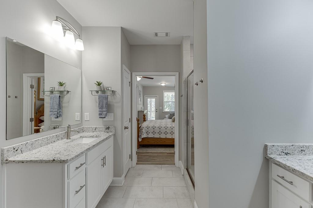 5188 Watchmans Cove Gainesville, GA 30504 - Photo 31 of 90 a bathroom with a granite countertop sink and a mirror