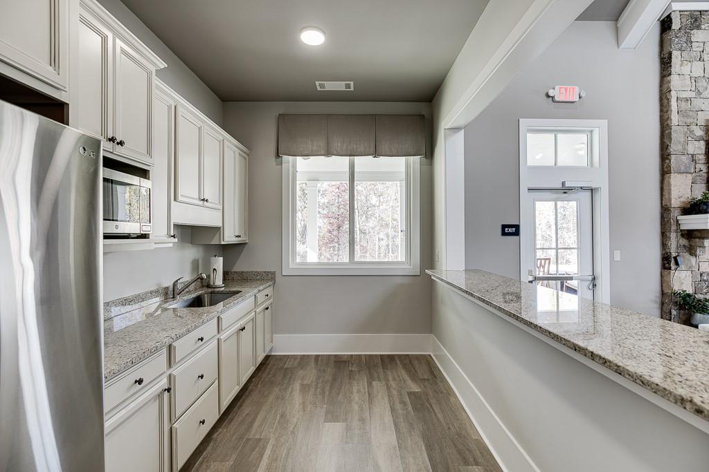 5188 Watchmans Cove Gainesville, GA 30504 - Photo 75 of 90 a kitchen with granite countertop a sink a counter space appliances and cabinets