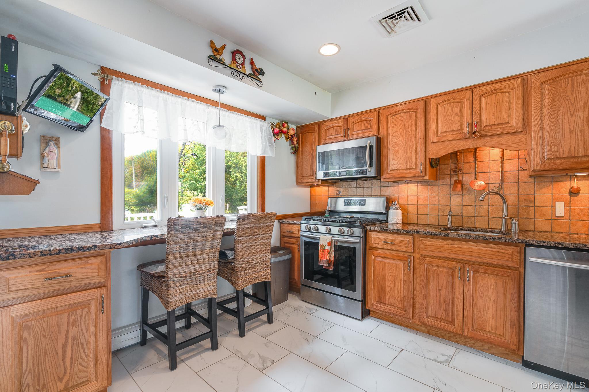 34 Raker Road Poughkeepsie, NY 12603 - Photo 9 of 27 a kitchen with stainless steel appliances granite countertop sink stove top oven table and chairs