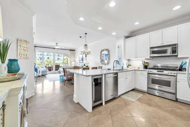 a kitchen with stainless steel appliances granite countertop grey cabinets a stove a sink and dishwasher