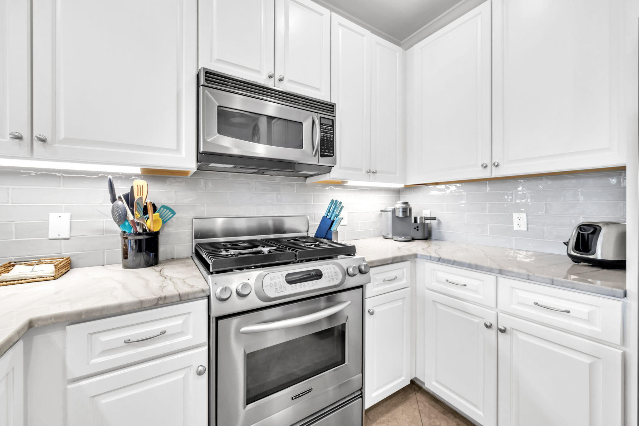 2421 West County Highway 30A, Unit F304 Santa Rosa Beach, FL 32459 - Photo 15 of 63 a kitchen with stainless steel appliances granite countertop grey cabinets a stove a sink and dishwasher