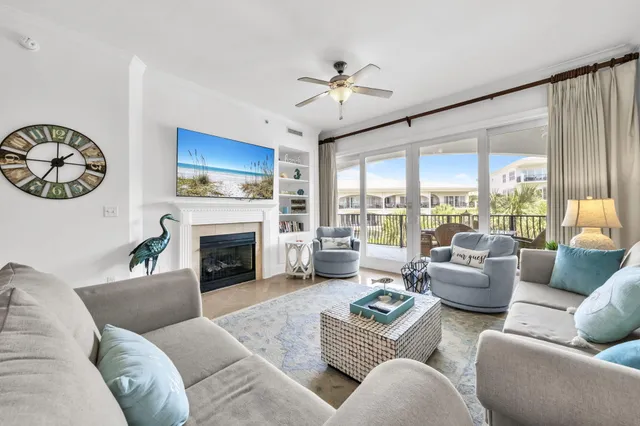 a living room with furniture a fireplace and a chandelier
