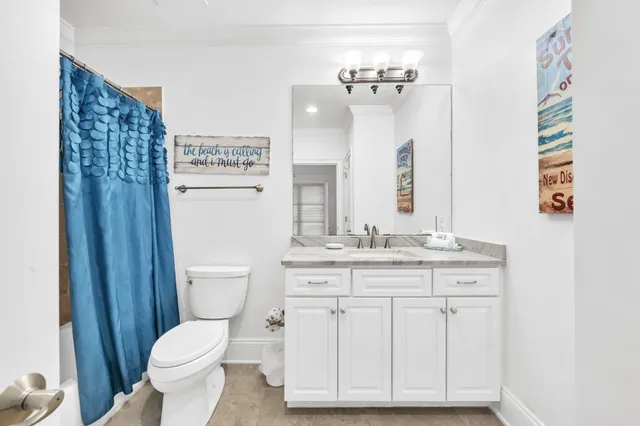 a bathroom with a granite countertop toilet sink and mirror