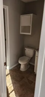 a white toilet sitting next to a small bathroom
