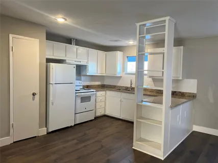 a kitchen with white cabinets and white appliances