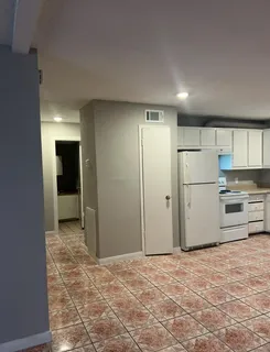 a view of a kitchen with a sink and refrigerator