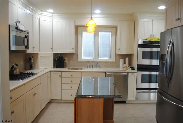 a kitchen with a sink stainless steel appliances and cabinets