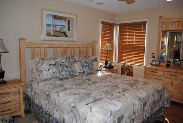 a large bed sitting in a bedroom next to a window and a lamp