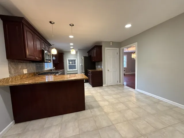 a view of kitchen with stainless steel appliances granite countertop a refrigerator and a sink