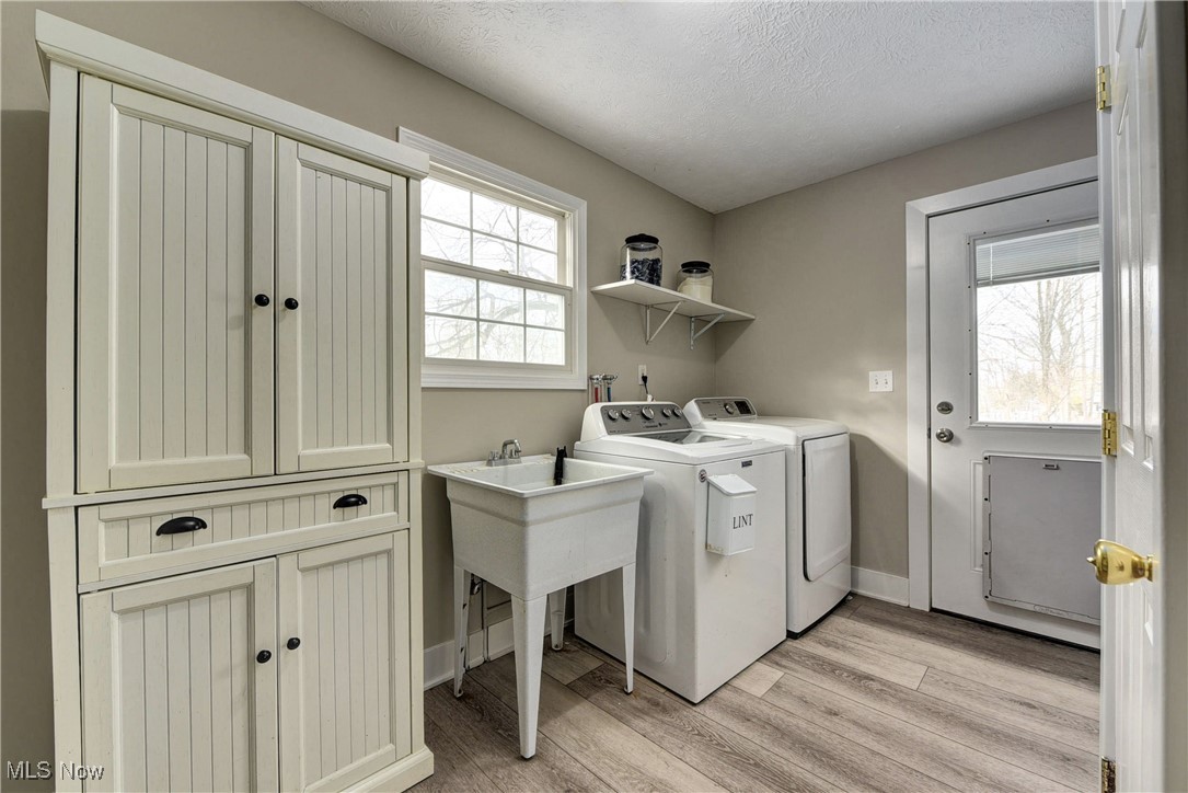 5927 Highland Road Highland Heights, OH 44143 - Photo 8 of 22 Washroom with washer and clothes dryer, light hardwood / wood-style flooring, and a textured ceiling