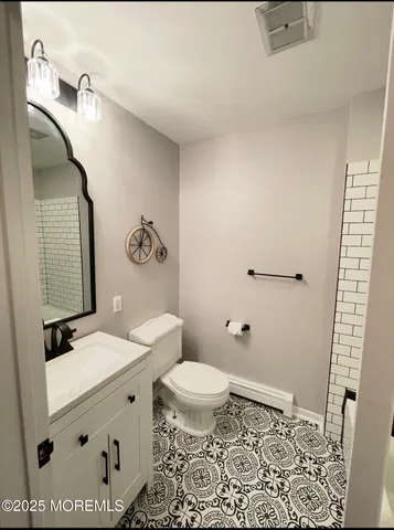 a bathroom with a granite countertop sink mirror vanity and toilet