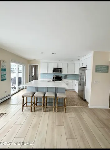 a view of a kitchen with furniture and wooden floor