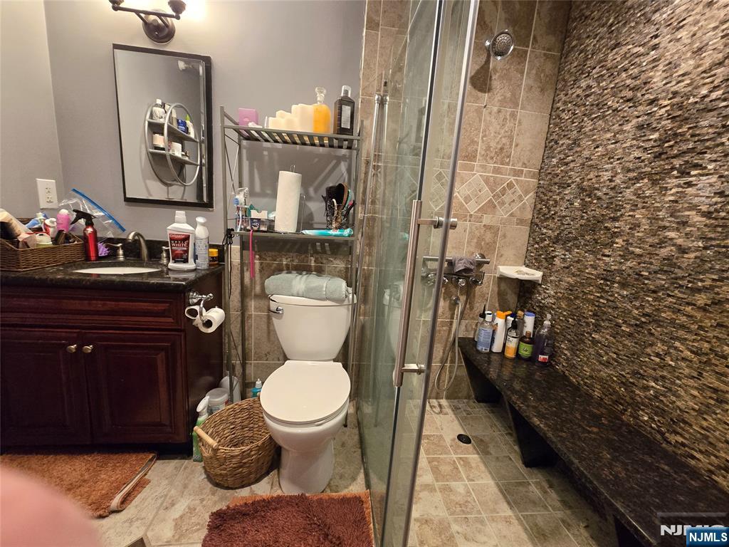 326 Prospect Avenue, Unit 1A Hackensack, NJ 07601 - Photo 15 of 19 a bathroom with a toilet a sink and mirror