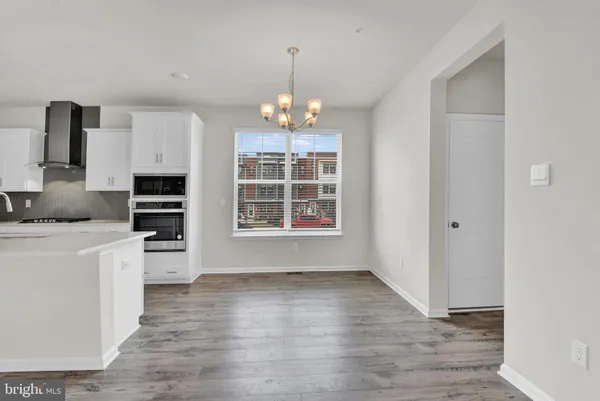a view of a kitchen with wooden floor and a window
