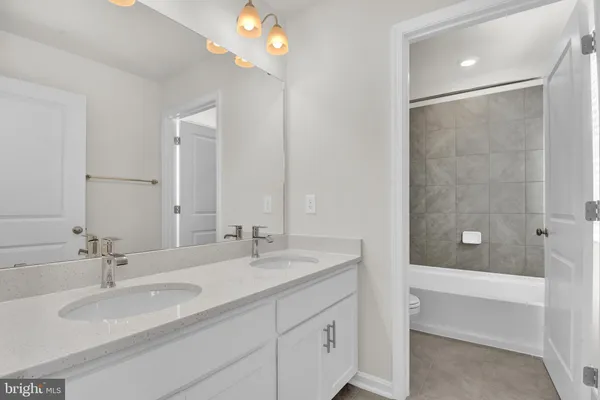 a bathroom with a double vanity sink mirror and shower