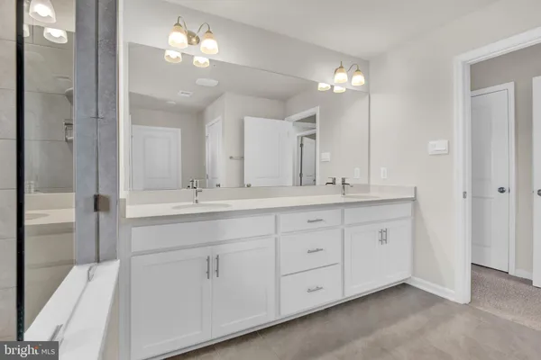 a bathroom with double vanity sink and a mirror