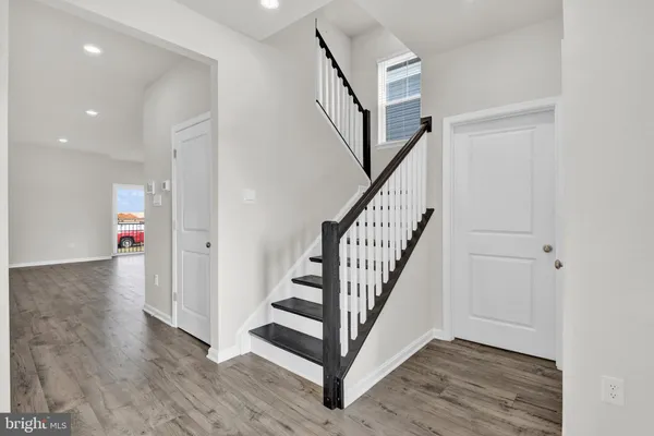 a view of a hallway with wooden floor and stairs