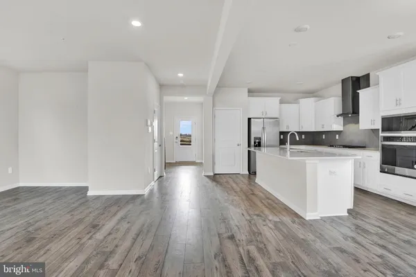 a view of kitchen with cabinets stainless steel appliances and wooden floor