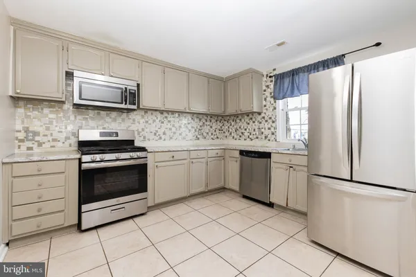 an empty room with wooden floor chandelier fan and windows