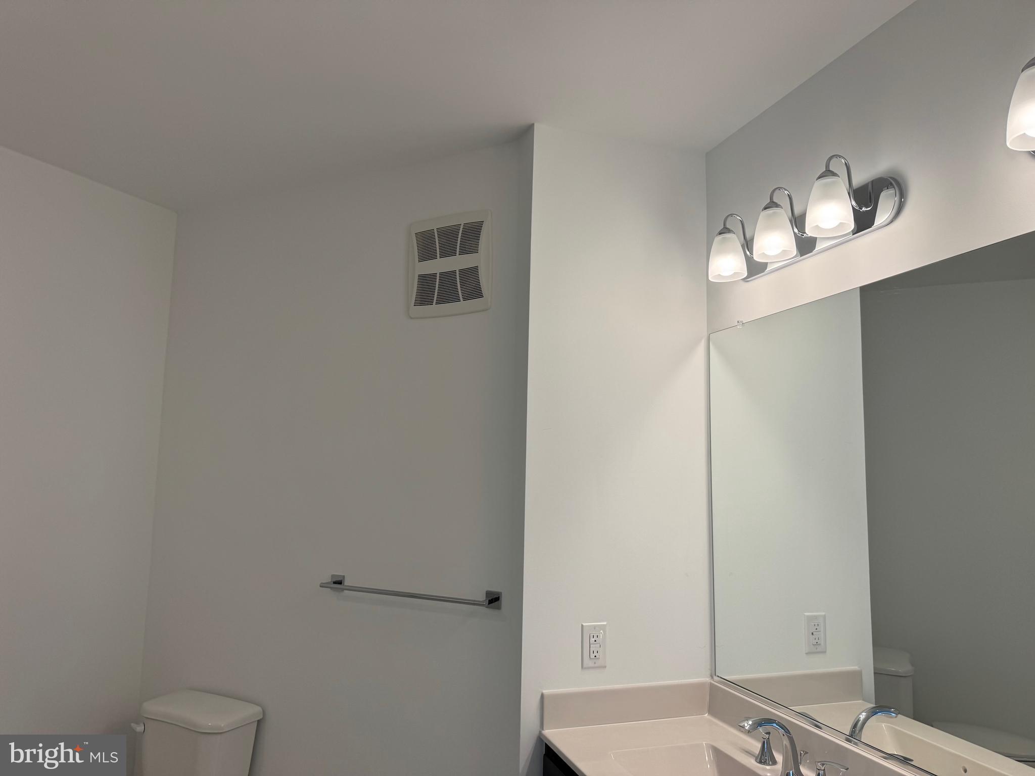 21731 Dovekie Terrace, Unit 408 Ashburn, VA 20147 - Photo 15 of 20 a bathroom with a sink a toilet and mirror