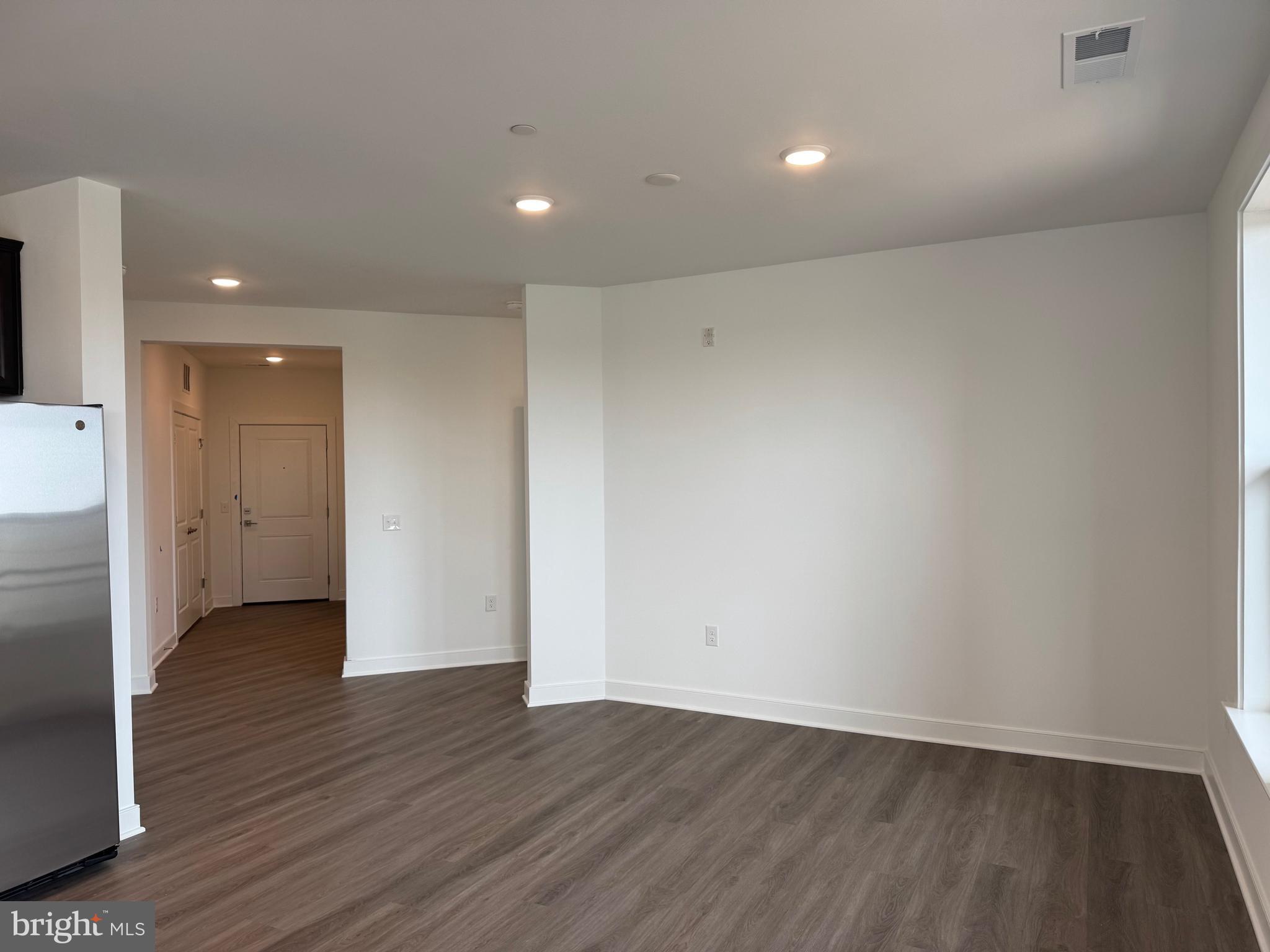 21731 Dovekie Terrace, Unit 408 Ashburn, VA 20147 - Photo 4 of 20 an empty room with wooden floor and windows