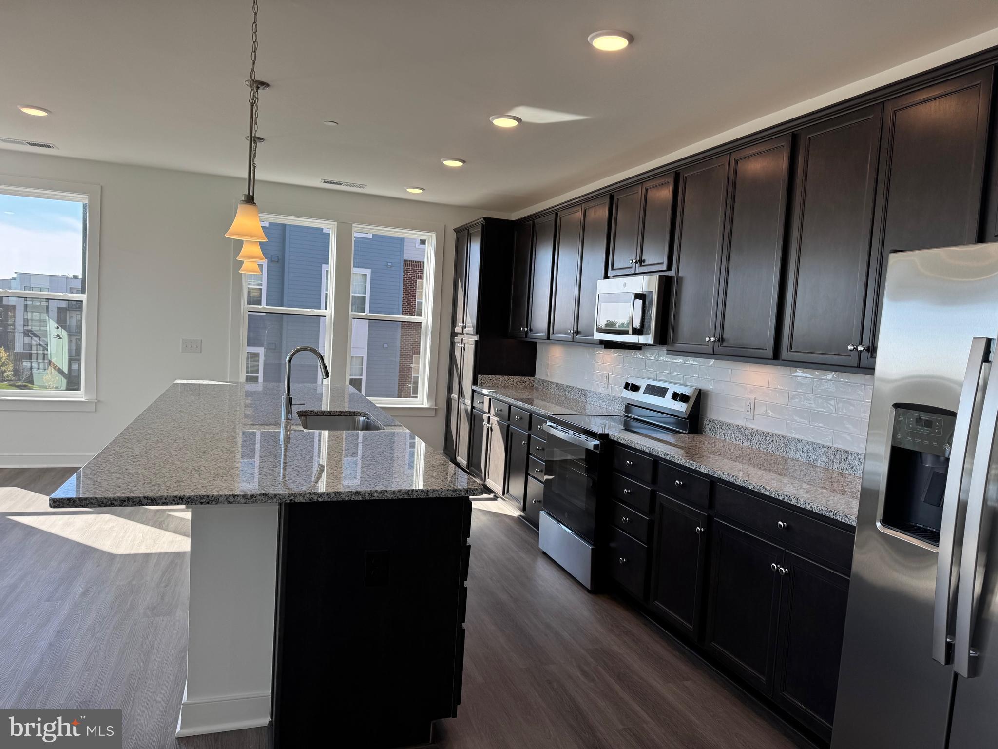 21731 Dovekie Terrace, Unit 408 Ashburn, VA 20147 - Photo 7 of 20 a kitchen with stainless steel appliances granite countertop a sink a stove and refrigerator