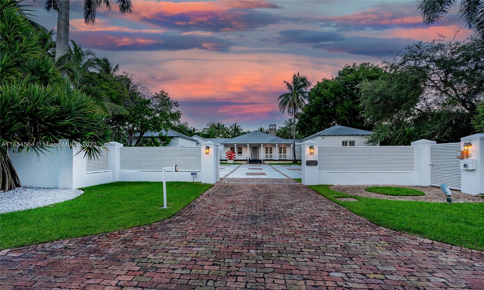 8325 School House Road Miami, FL 33143 - Photo 18 of 21 a front view of a house with a yard and garage