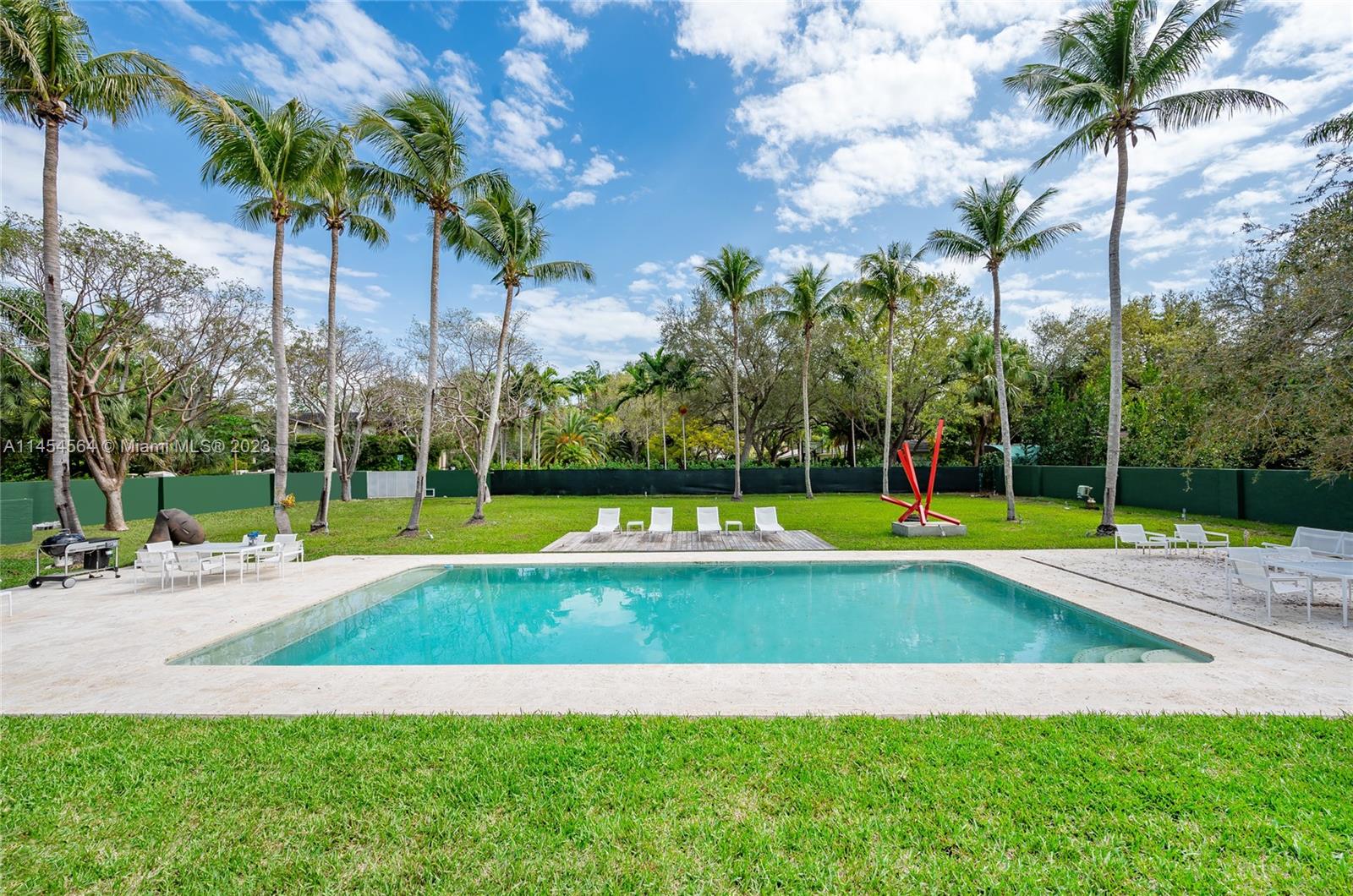 8325 School House Road Miami, FL 33143 - Photo 4 of 21 a view of a swimming pool with a yard and palm trees