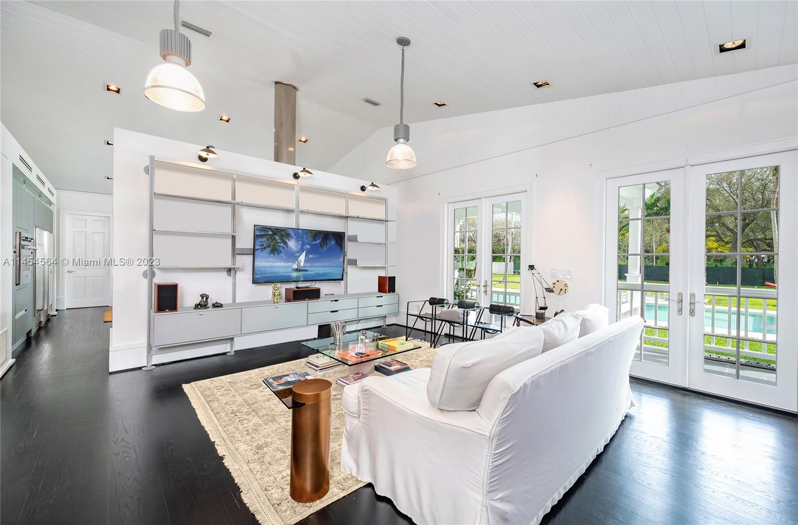 8325 School House Road Miami, FL 33143 - Photo 6 of 21 a living room with furniture a wooden floor and a chandelier