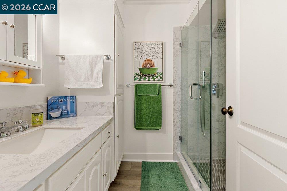 2001 Golden Rain Road, Unit 4 Walnut Creek, CA 94595 - Photo 25 of 60 a bathroom with a granite countertop sink a mirror and shower