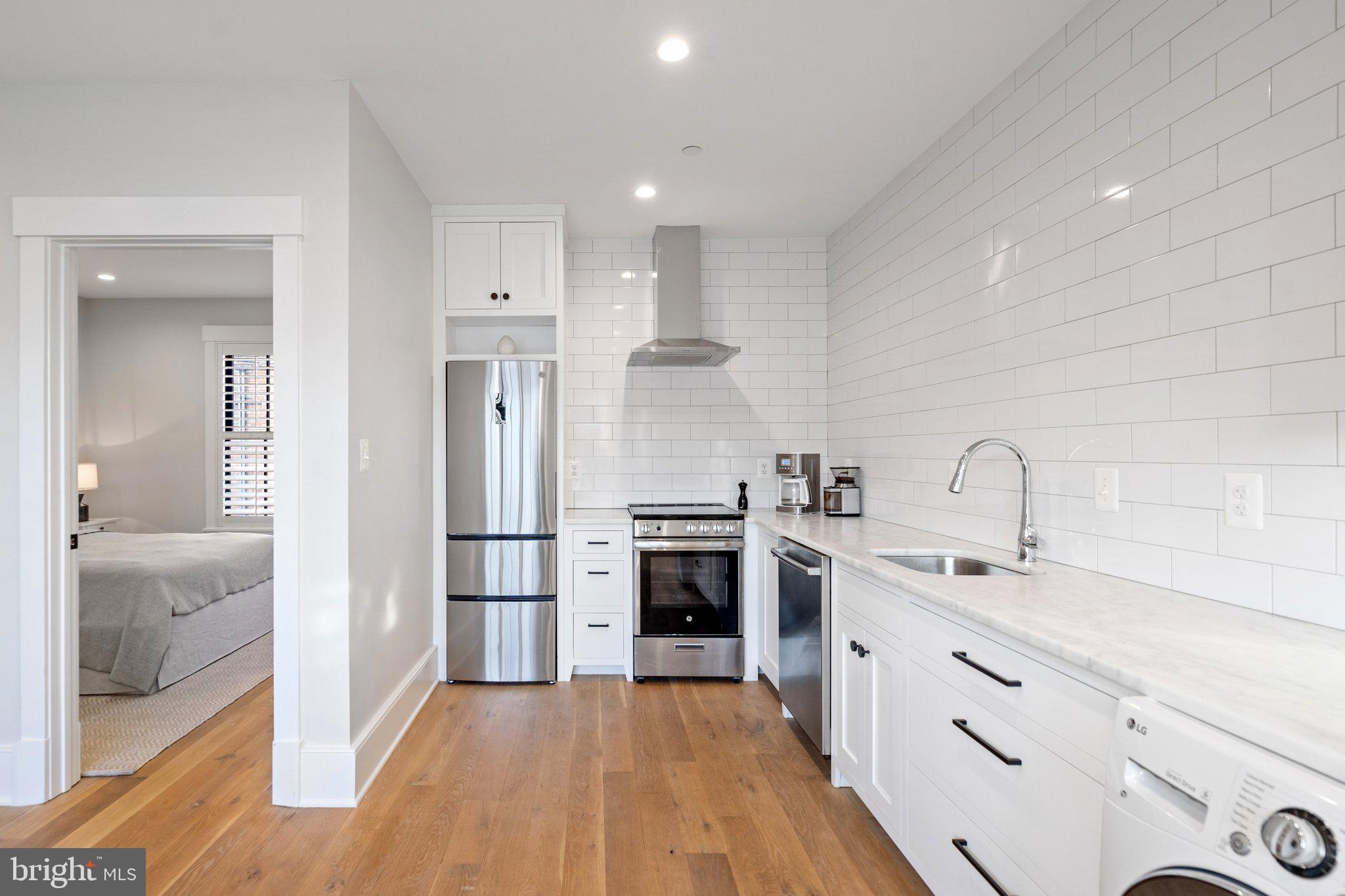 214 A Street Northeast Washington, DC 20002 - Photo 60 of 78 a kitchen with stainless steel appliances granite countertop a sink and a stove top oven