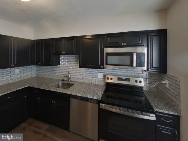 a kitchen with granite countertop stainless steel appliances and cabinets