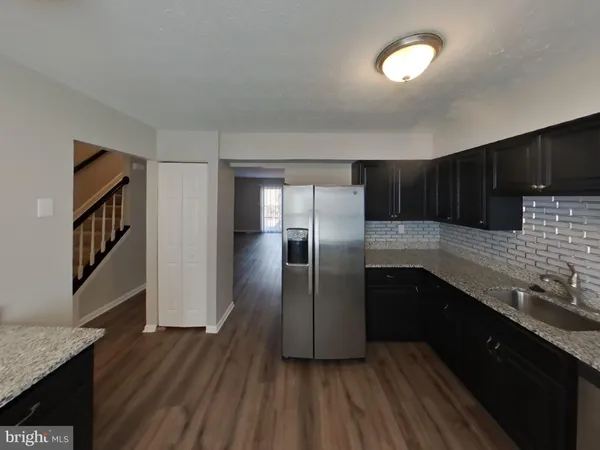 a kitchen with granite countertop a refrigerator and a sink