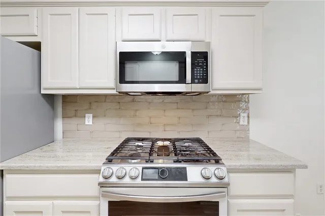 a stove top oven sitting inside of a kitchen