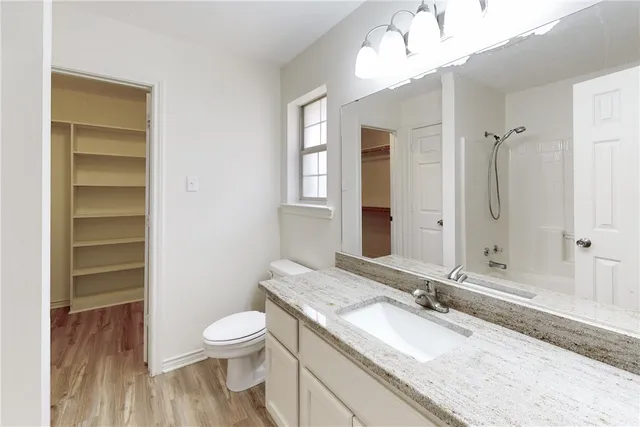 a bathroom with a granite countertop sink toilet a large mirror and shower