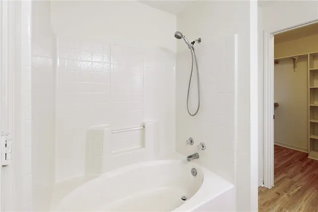 a bathroom with a bath tub with a shower