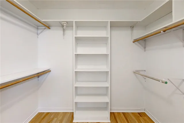 a view of walk in closet with empty racks