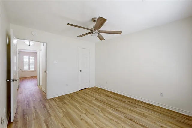 a view of a room with wooden floor and a ceiling fan