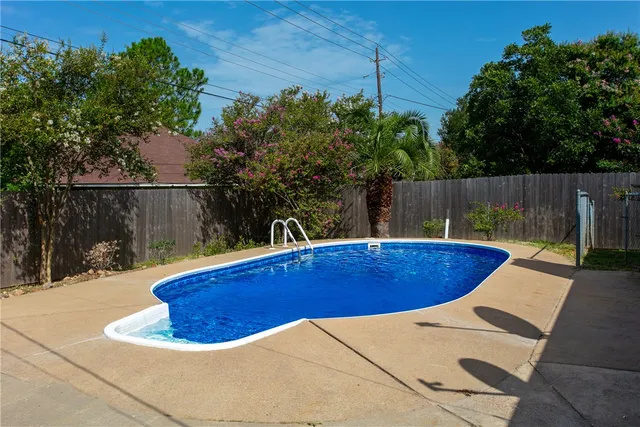a view of a backyard with swimming pool