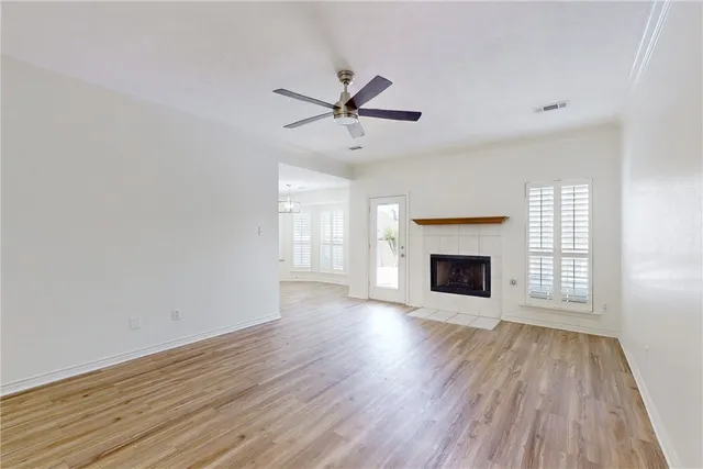 wooden floor fireplace and windows in an empty room