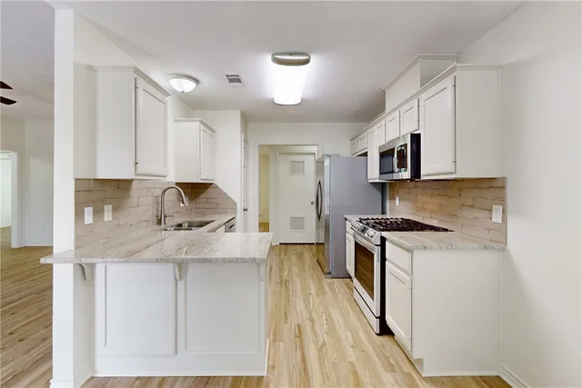 a kitchen with stainless steel appliances granite countertop a stove a sink and a refrigerator