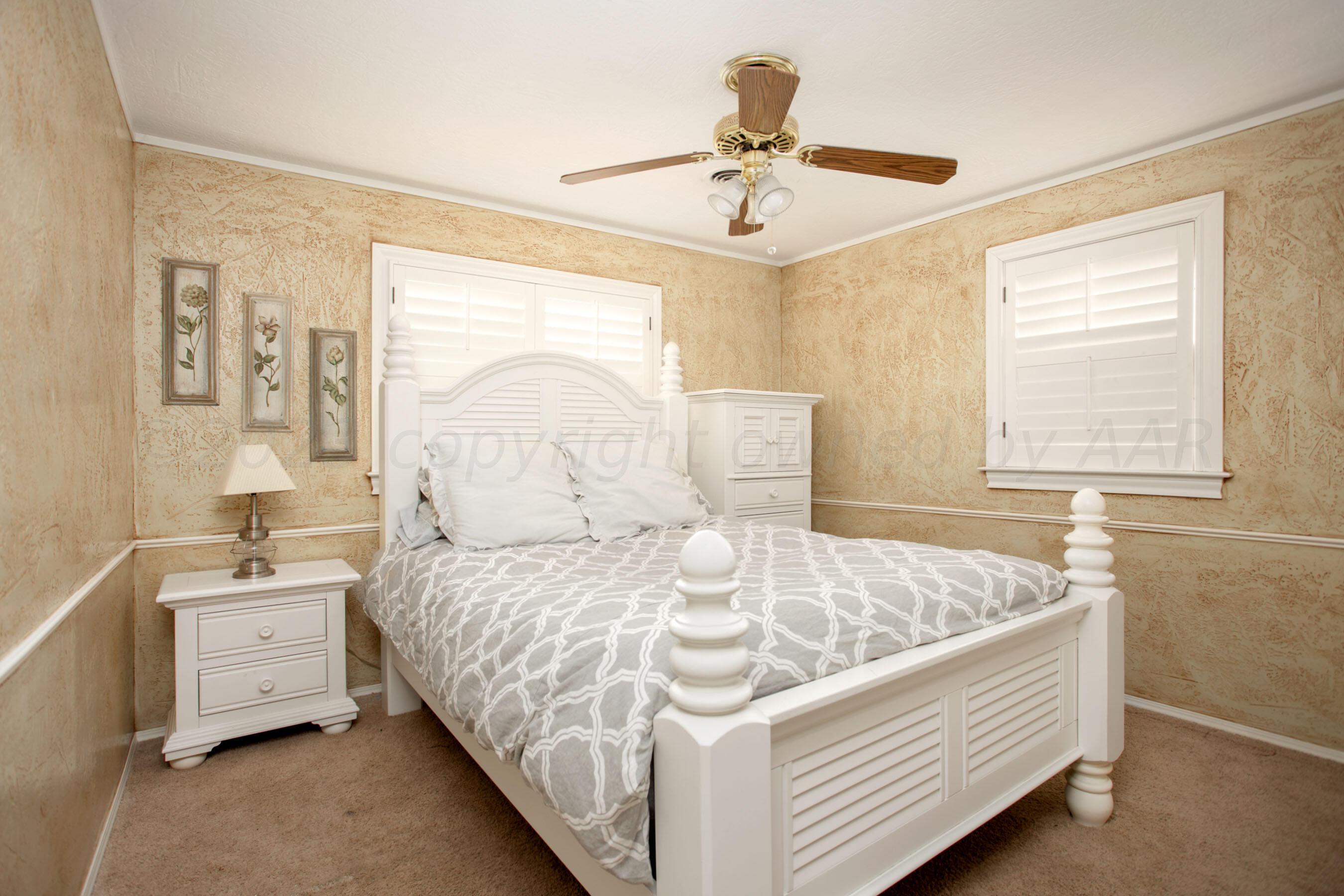 5013 South Bonham Street Amarillo, TX 79110 - Photo 13 of 27 a bed room with a bed and a chandelier