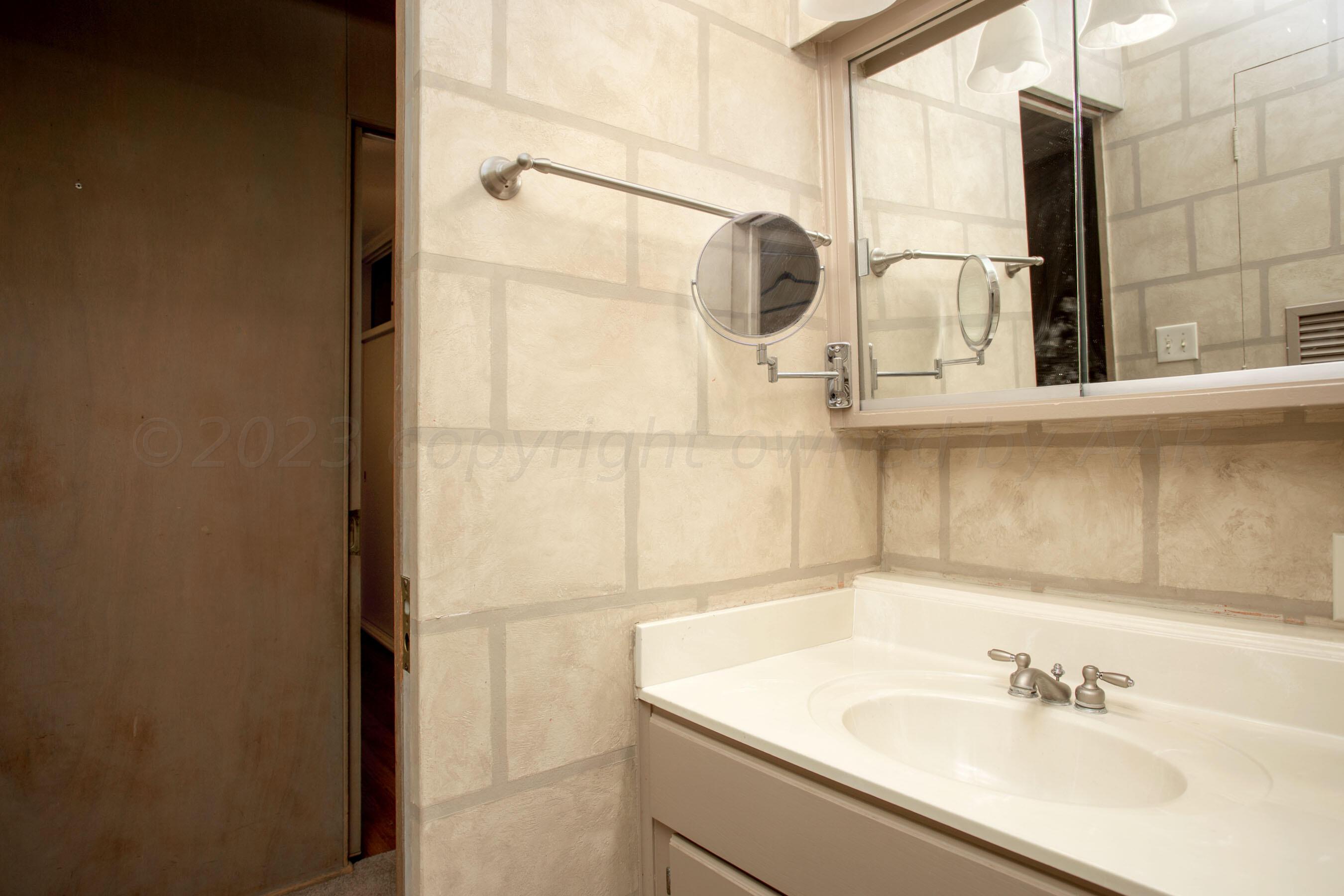 5013 South Bonham Street Amarillo, TX 79110 - Photo 19 of 27 a bathroom with a sink and mirror