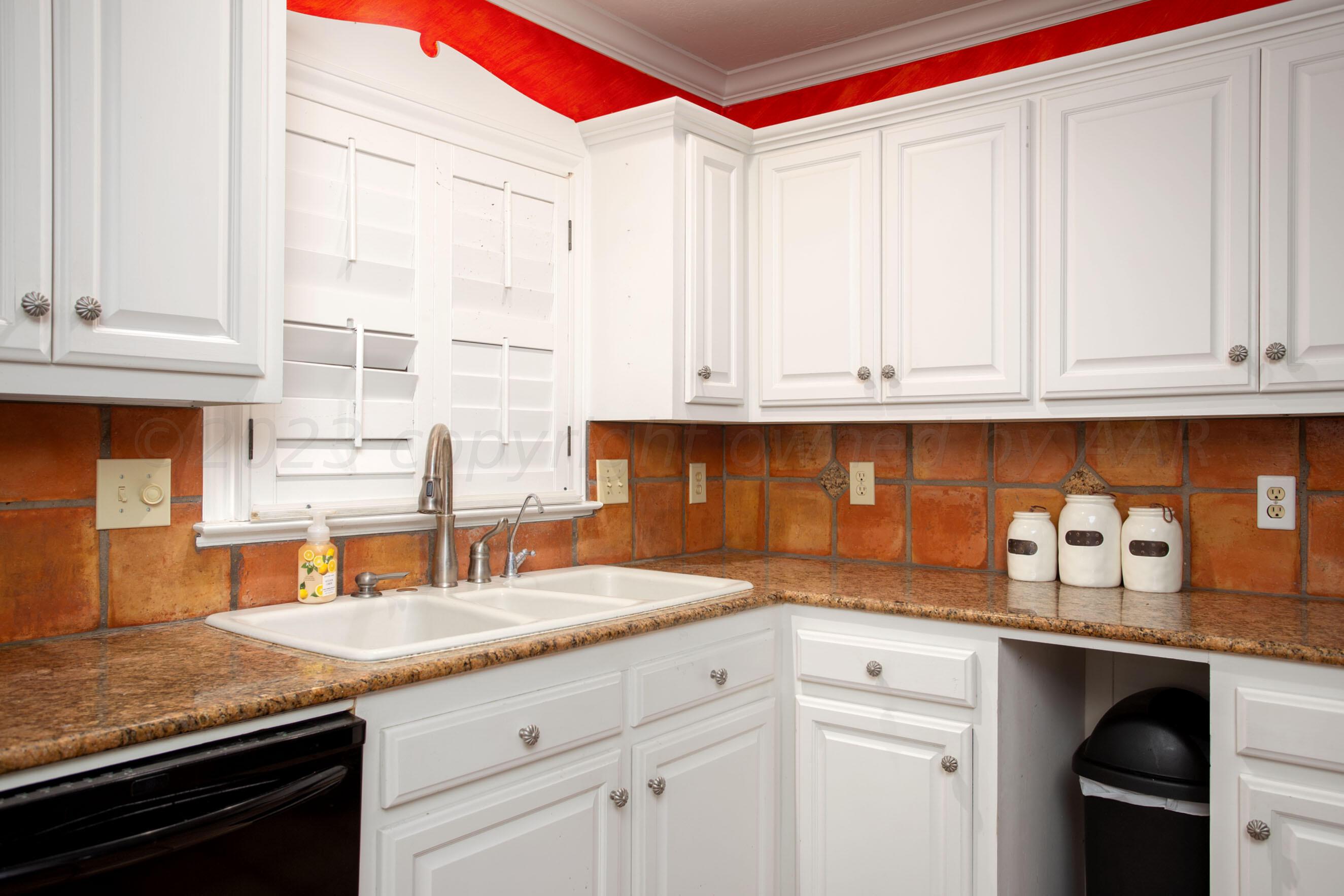 5013 South Bonham Street Amarillo, TX 79110 - Photo 6 of 27 a kitchen with stainless steel appliances granite countertop a sink and cabinets with wooden floor
