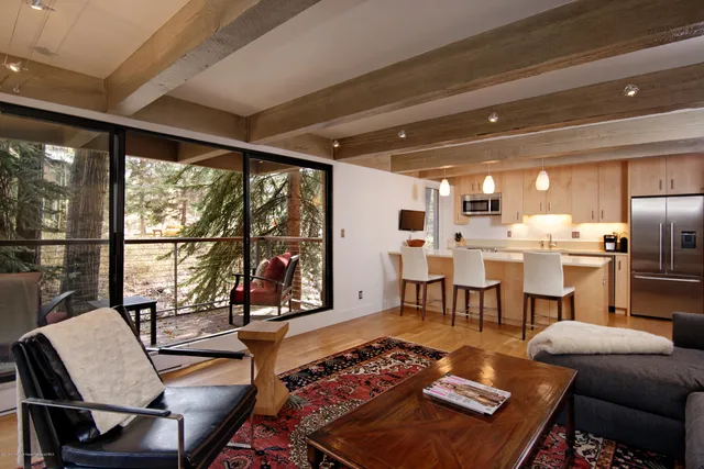 a living room with couches a coffee table and chairs with outer view