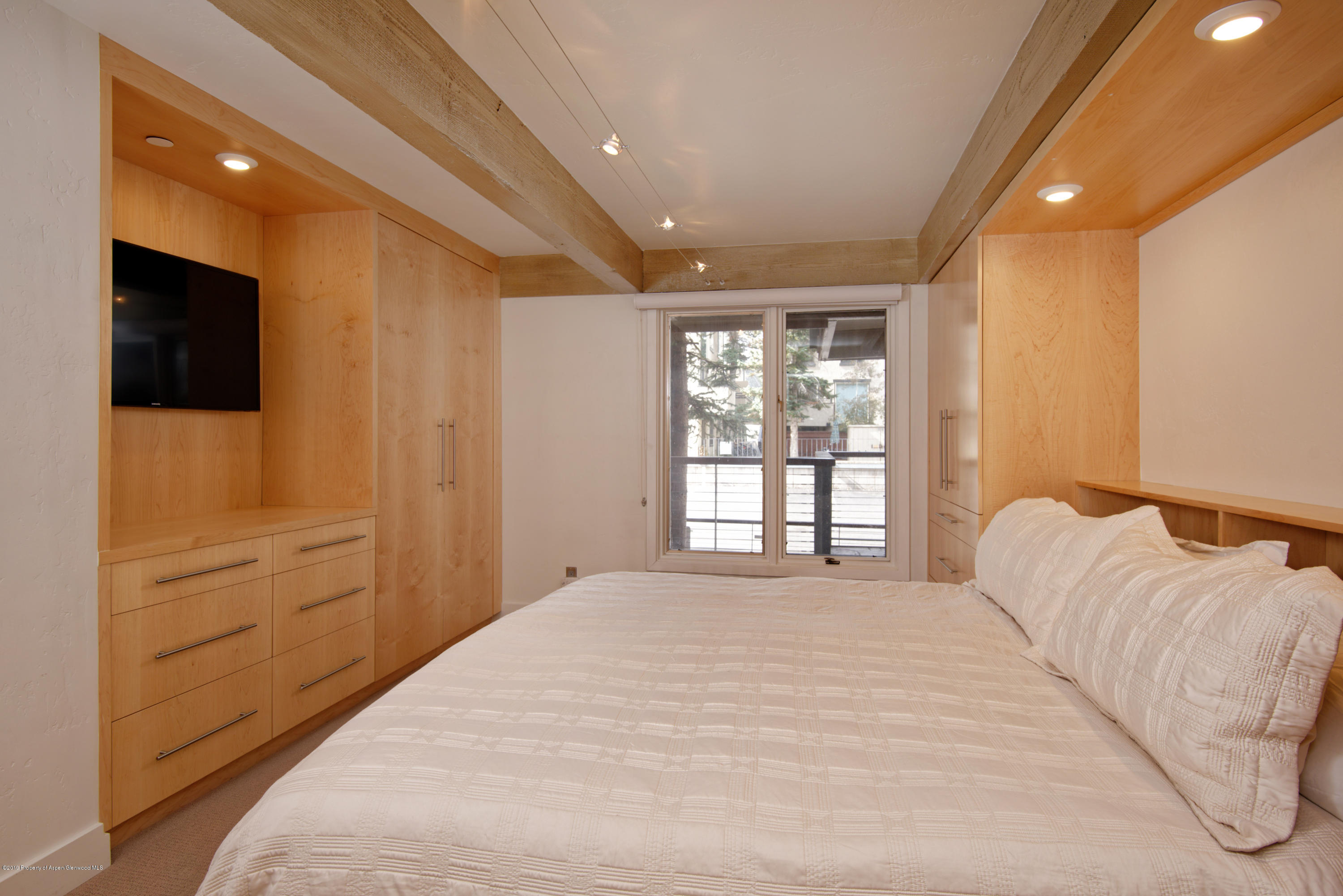 1034 East Cooper Avenue, Unit 5A Aspen, CO 81611 - Photo 9 of 15 a bedroom with a large bed and a flat tv screen on dresser