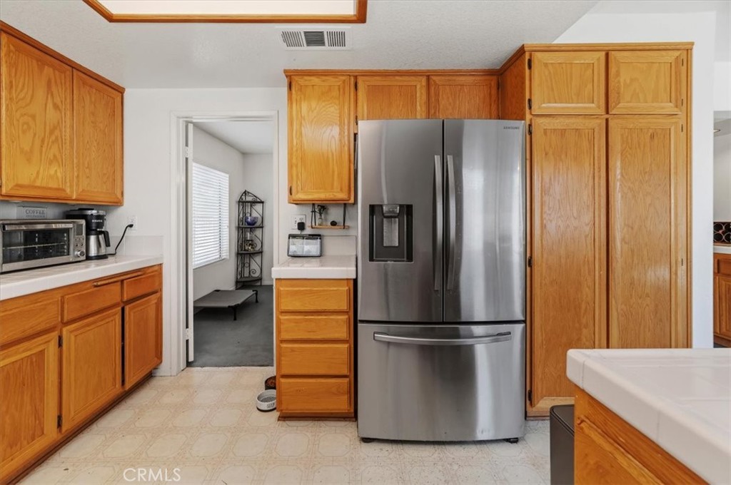 352 Leafwood Court Riverside, CA 92506 - Photo 13 of 42 a kitchen with stainless steel appliances a refrigerator and cabinets