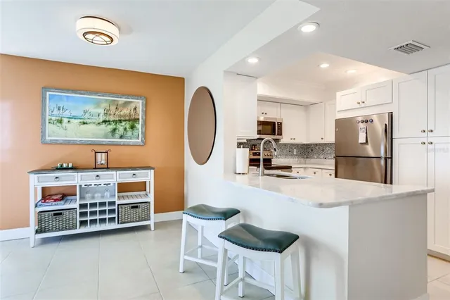 a kitchen with stainless steel appliances a refrigerator sink and white cabinets