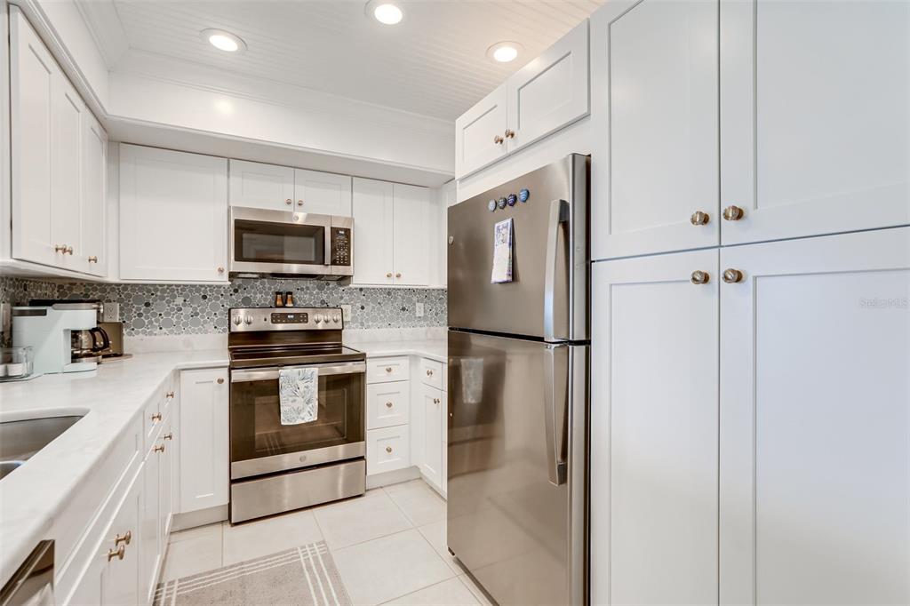 2955 North Beach Road, Unit A432 Englewood, FL 34223 - Photo 8 of 24 a kitchen with stainless steel appliances a refrigerator sink and white cabinets