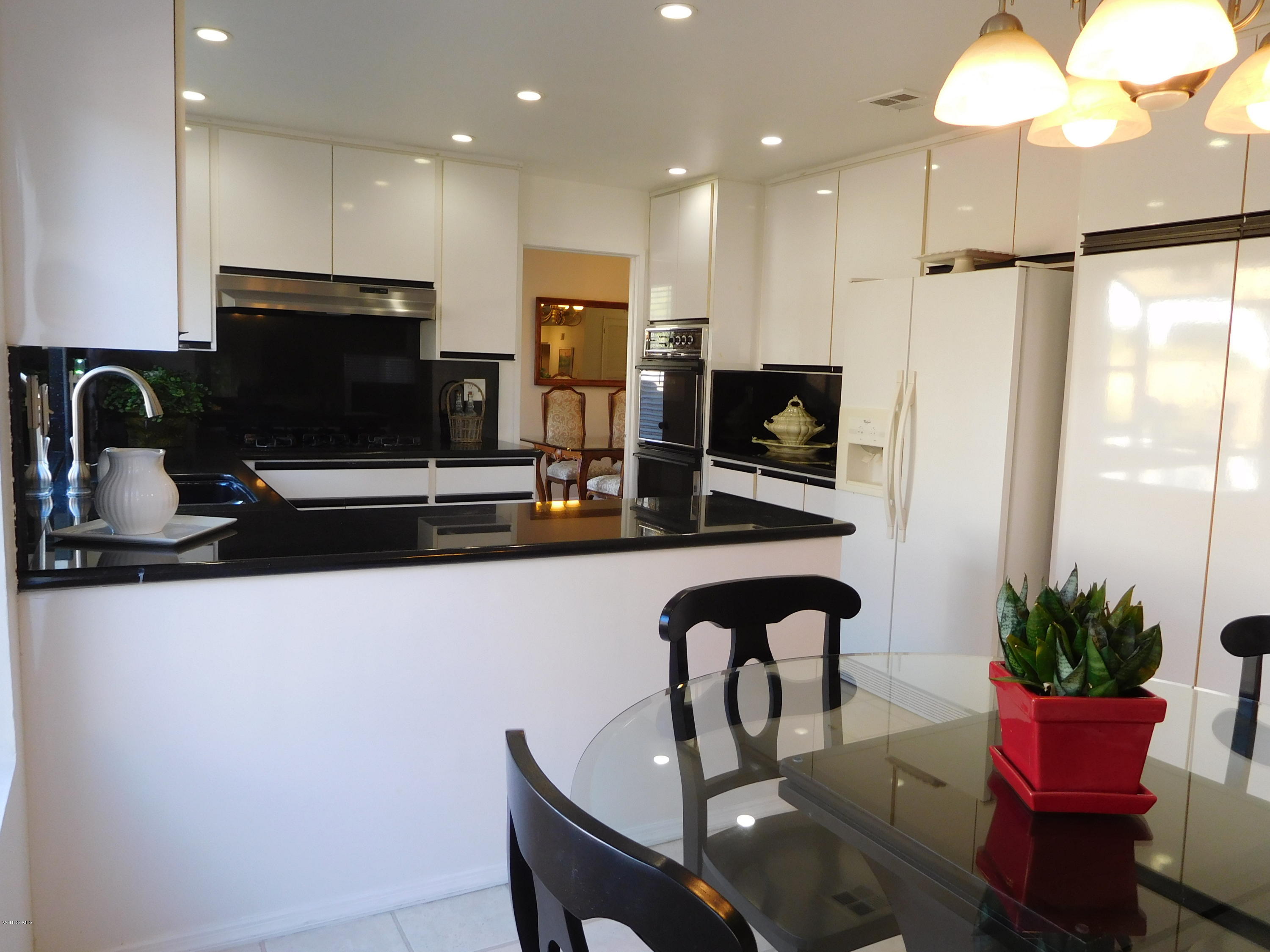 12531 Spring Creek Road Moorpark, CA 93021 - Photo 14 of 30 a kitchen with a table a refrigerator and chairs